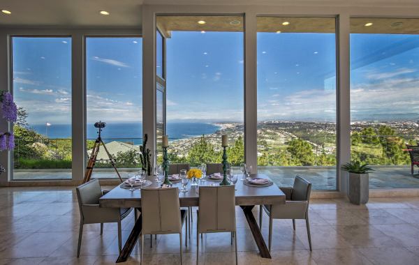 Interior shot of a dining room with floor-to-ceiling windows showcasing the Napa Valley below