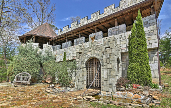 Castle vacation rental with drawbridge and trees surrounding